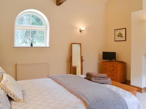 a bedroom with a bed and a window and a dresser at Binbrook House Mews in binbrook