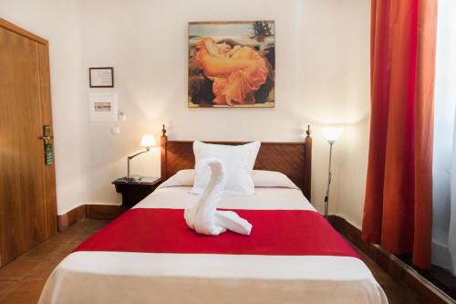 a hotel room with a bed with a towel animal on it at Casa Palacio Pilar del Toro in Granada