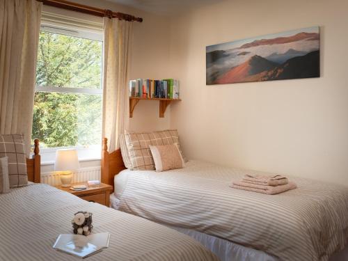 a small bedroom with two beds and a window at Flat 4 in Keswick