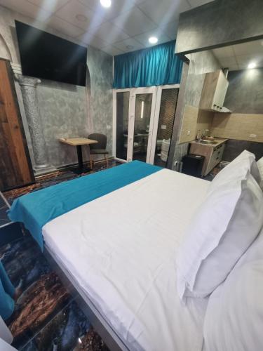 a large white bed in a room with a table at Poet Palace Bucharest in Bucharest