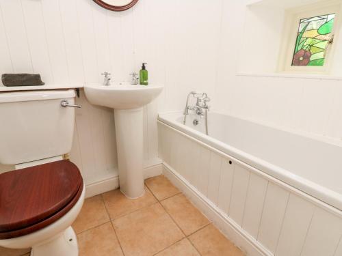 een badkamer met een toilet, een wastafel en een bad bij Hepple Hill Cottage in Consett