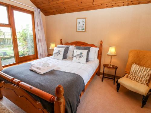een slaapkamer met een bed, een stoel en een raam bij Hepple Hill Cottage in Consett