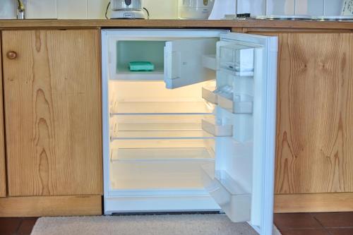 an empty refrigerator with its door open in a kitchen at Appartements Bernhofer in Saalbach Hinterglemm