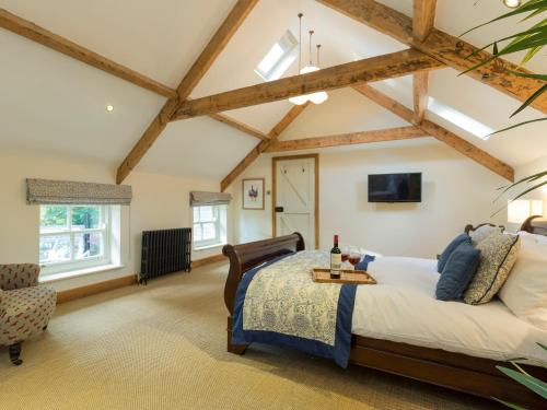 a bedroom with a large bed and a ceiling with beams at The Coach House in Ridingmill