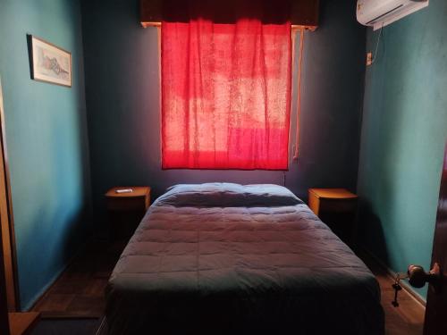 um quarto com uma cama e uma janela vermelha em Patio Urbano Suites & beds em Montevidéu