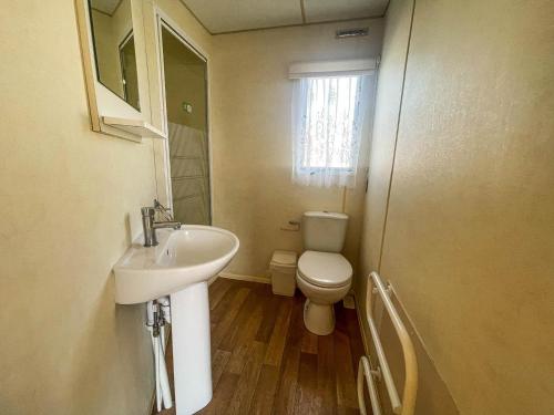 a small bathroom with a sink and a toilet at 8 Berth Caravan At California Cliffs By Scratby Beach In Norfolk Ref 50001d in Great Yarmouth