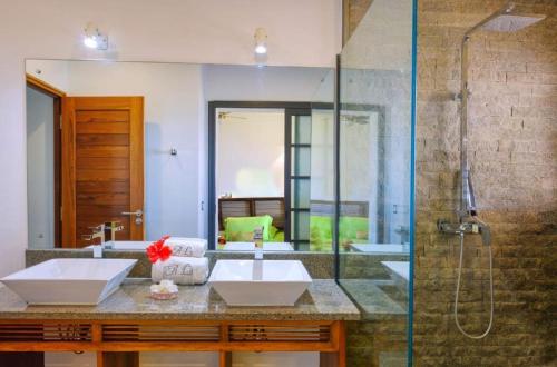 a bathroom with two sinks and a shower at ANJARA LODGE Villa de 3 chambres in Nosy Be