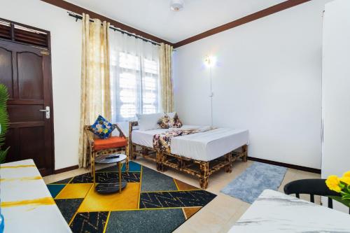 a bedroom with a bed and a chair and a window at Shikamoo Spacious Studio Nyali in Mombasa