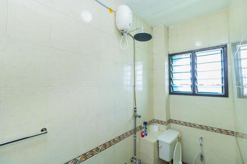 a bathroom with a shower and a toilet and a window at Shikamoo Spacious Studio Nyali in Mombasa