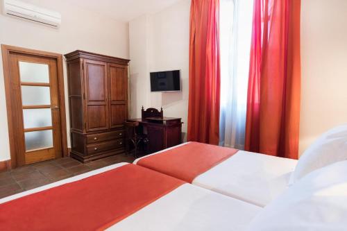 a bedroom with a bed with red curtains and a cabinet at Casa Palacio Pilar del Toro in Granada