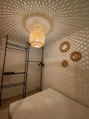- une chambre dotée d'un plafond avec un lit et une lumière dans l'établissement Appartement rénové à 150 m de la plage le BARCARES, au Barcarès