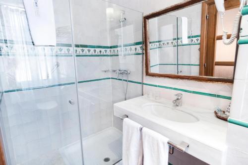 a bathroom with a shower and a sink and a mirror at Casa Palacio Pilar del Toro in Granada