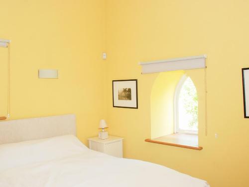 um quarto com uma cama branca e uma janela em The Byre em West Stour