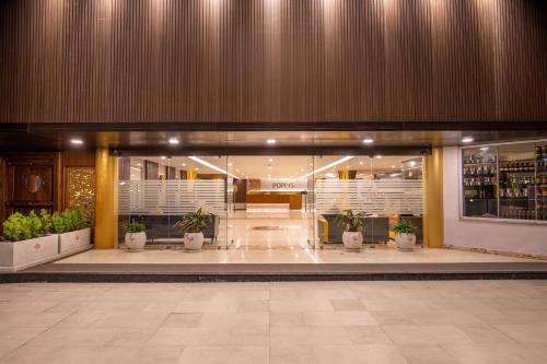 a lobby of a building with potted plants at Poppys Pleasant Stay in Kodaikānāl
