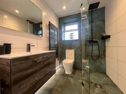 a bathroom with a toilet and a glass shower at Little Croft in Holywell Bay