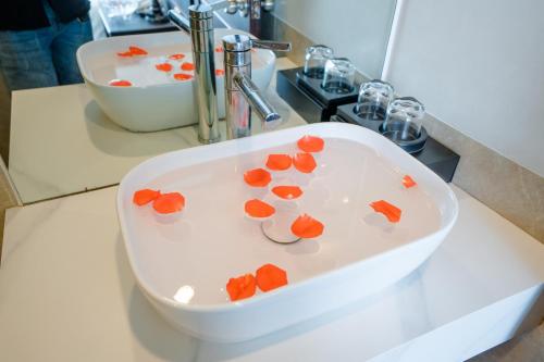 a white sink with orange flowers in it in a bathroom at Ha Noi Lake View Hotel & Travel in Hanoi