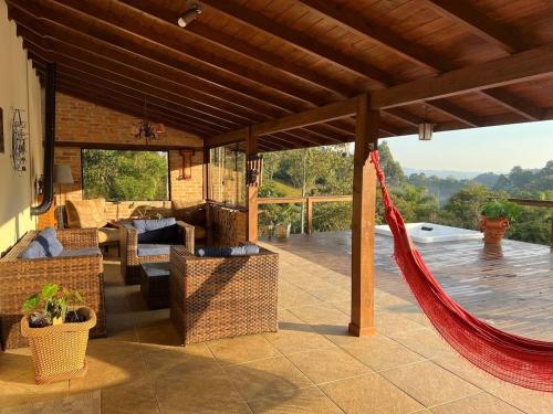 eine Terrasse mit Hängematte auf einem Haus in der Unterkunft Quinta da Serra - Onde o charme se mistura com a natureza in Rancho Queimado