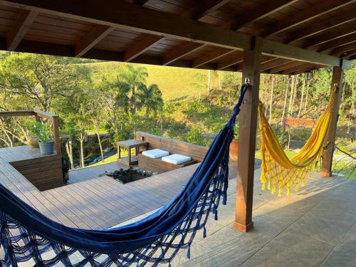 una hamaca en una terraza con un banco y una mesa en Quinta da Serra - Onde o charme se mistura com a natureza, en Rancho Queimado