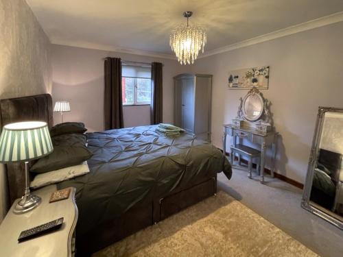 a bedroom with a bed and a desk and a mirror at Winston Lodge in Swinderby