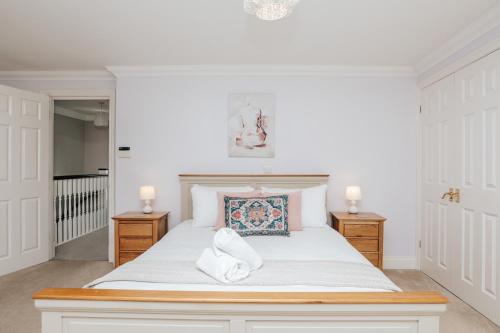 a bedroom with a large white bed with two lamps at Olive Tale in Henley on Thames