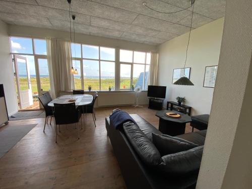 een woonkamer met een bank en een tafel bij Skærven Beachfront Apartments and Cottage in Nyborg