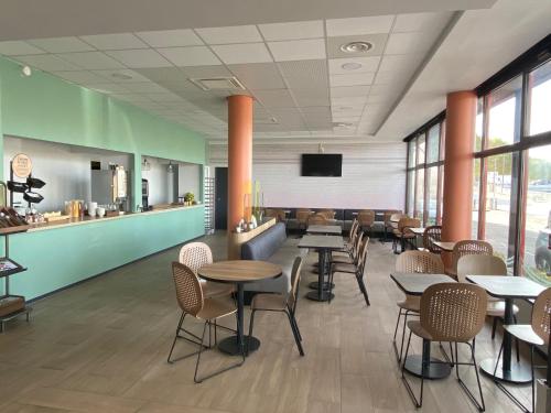 un restaurant avec des tables et des chaises et un bar dans l'établissement B&B HOTEL Montluçon Centre, à Montluçon