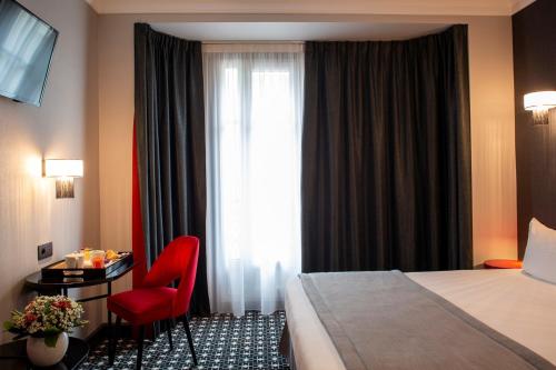 a hotel room with a bed and a red chair at Lenox Montparnasse in Paris