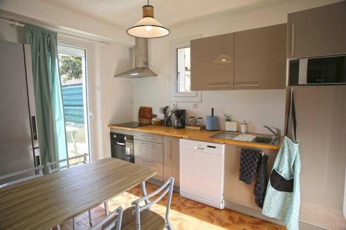 - une cuisine avec une table en bois et un comptoir dans l'établissement La maison verd'O Sisteron, à Sisteron