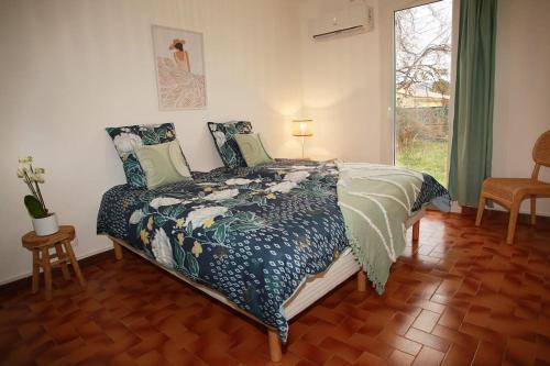 um quarto com uma cama e uma janela em La maison verd'O Sisteron em Sisteron