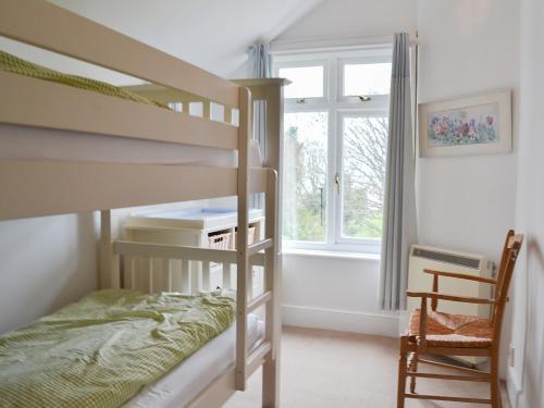 a bedroom with two bunk beds and a window at Beech Cottage in Whitwell