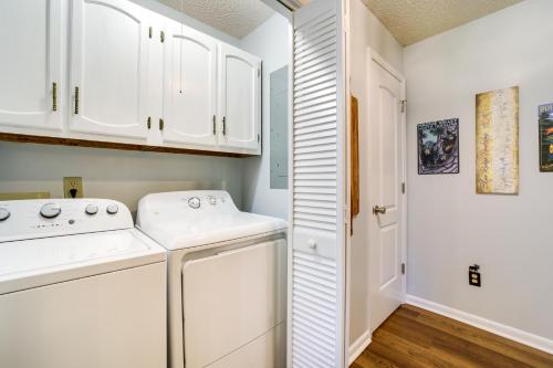 a laundry room with white cabinets and a washer and dryer at Peaceful Maggie Valley Vacation Rental with Fire Pit in Maggie Valley