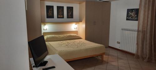 a small bedroom with a bed and a flat screen tv at Appartamento Camera Da Stefy in Bastia Umbra