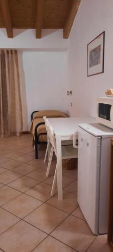 eine Küche mit einem weißen Tisch und einer Mikrowelle in der Unterkunft Appartamento Camera Da Stefy in Bastia Umbra