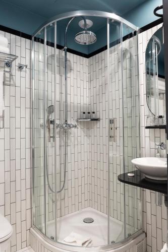a bathroom with a shower and a sink at Lenox Montparnasse in Paris