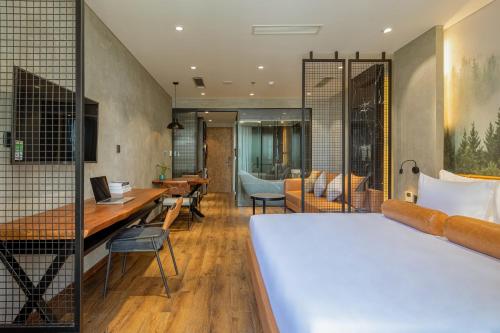 a hotel room with a bed and a desk at Taiyo Hotel & Apartment in Da Nang