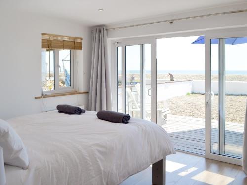 a bedroom with a bed with a view of the beach at Salty Lodge in South Hayling