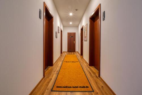 a hallway with a yellow rug on the floor at Zentrum Hotel Stade in Stade