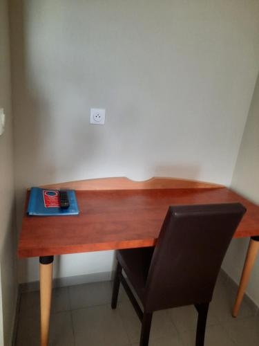 - un bureau en bois avec un livre et une chaise dans l'établissement Logis Hôtel et Restaurant La Croix de Mille, à Pampelonne