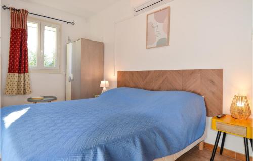 - une chambre avec un lit bleu et une fenêtre dans l'établissement 1 Bedroom Beautiful Home In Mouris, à Mouriès