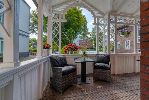 a porch with chairs and a table on a building at Zentrum Hotel Stade in Stade