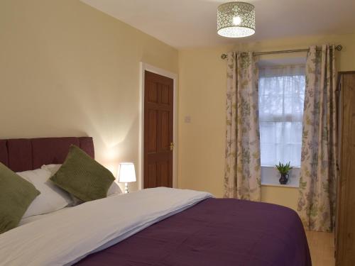 - une chambre avec un lit et une fenêtre dans l'établissement Brookside Cottage, à Forton