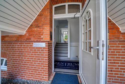 an open door of a brick building with a staircase at Zentrum Hotel Stade in Stade