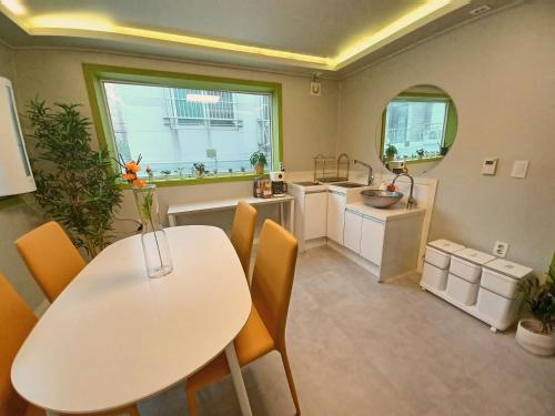 cocina con mesa blanca, sillas y fregadero en Four Seasons House (Female only), en Seúl
