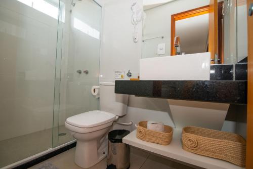 a bathroom with a toilet and a glass shower at Sea Paradise Hospedagem in Fernando de Noronha