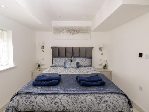 a bedroom with a large bed with blue pillows at The Penthouse, Strawberry Hill Vineyard in Newent