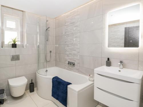 ein Badezimmer mit einer Badewanne, einem WC und einem Waschbecken in der Unterkunft The Penthouse, Strawberry Hill Vineyard in Newent