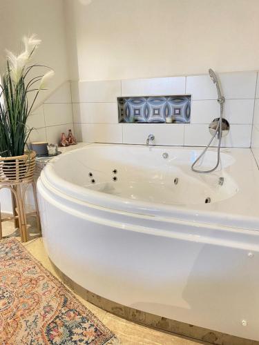 Una gran bañera blanca en una habitación. en סלע-וי, en Yonatan