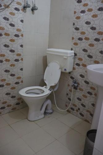 a bathroom with a toilet and a sink at Hotel Tourist Home By palak Hospitality in Mussoorie