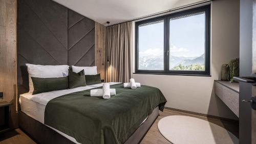a bedroom with a large bed with two towels on it at Panorama Eagle Lodge in Hart im Zillertal
