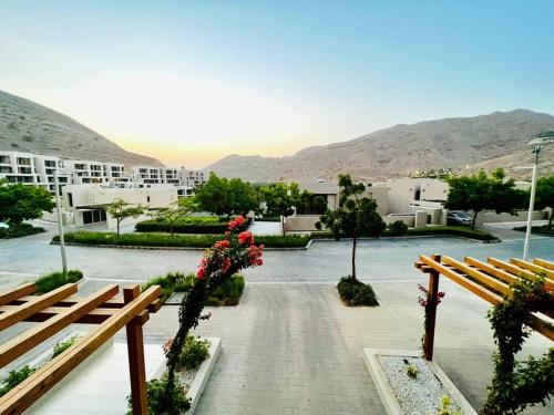 a view of a courtyard with benches and buildings at One Bedroom Apartment MuscatBay in Muscat